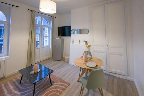 un salon avec une table et un réfrigérateur dans l'établissement Le Lupin - Petite terrasse - 250m plage, à Étretat