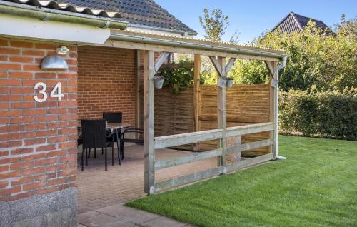 a wooden pergola with a table in a backyard at Awesome Home In Tønder With Wifi in Tønder