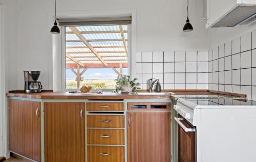 a kitchen with wooden cabinets and a large window at Awesome Home In Tønder With Wifi in Tønder