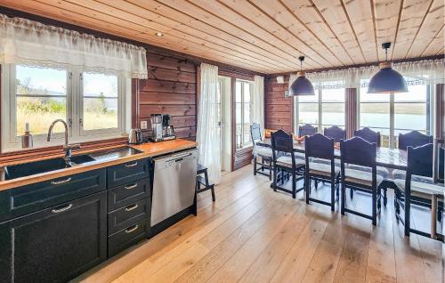 a kitchen with black cabinets and a table with chairs at Gorgeous Home In Gol With Sauna in Gol