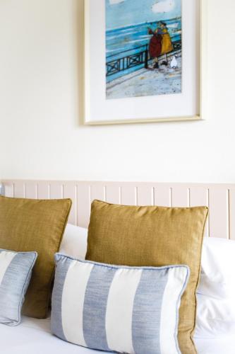 a white couch with pillows and a picture on the wall at The Peninsula Hotel in Vale