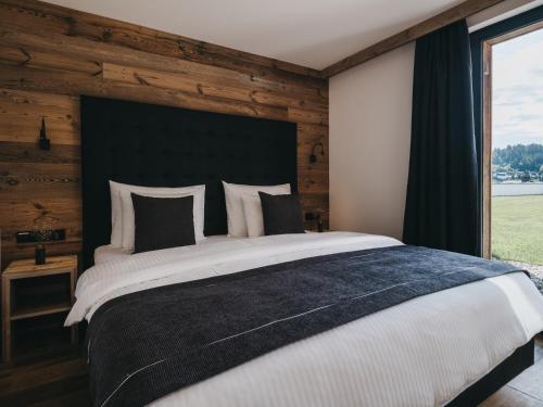 a bedroom with a large bed with a wooden wall at VAYA Fieberbrunn inklusive Gästekarte in Fieberbrunn
