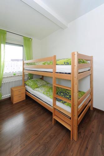 two bunk beds in a room with a window at Haus Hafenromantik in Neuharlingersiel