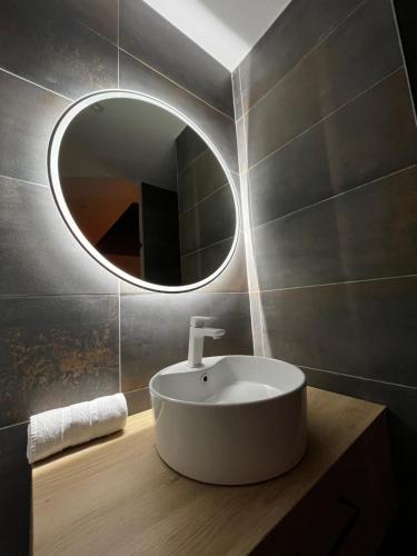 a bathroom with a sink and a mirror at Love room - Parenthèse romantique avec spa privé in Le Perrier