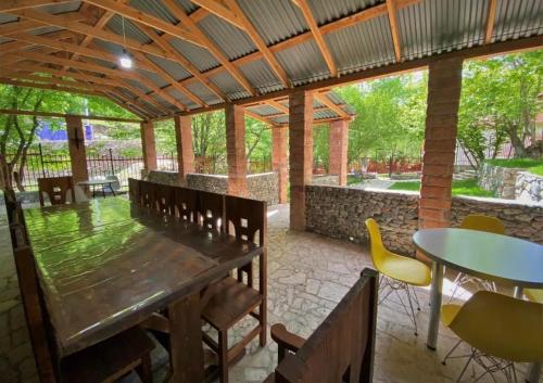 a patio with a wooden table and chairs and tables at Meghu Guest House in Aghavnavankʼ