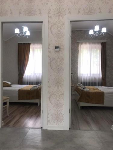 a reflection of a bedroom with two beds and a mirror at Meghu Guest House in Aghavnavankʼ