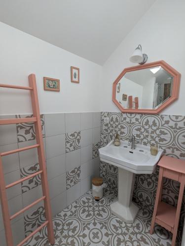 une salle de bain avec un lavabo et un miroir dans l'établissement La Maison Cornon, à Trumilly