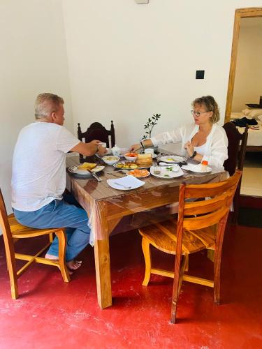 a man and woman sitting at a table eating food at Millenium Lodge - Anuradhapura in Anuradhapura