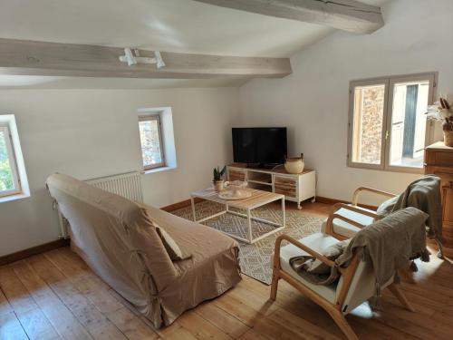 ein Wohnzimmer mit Sofa und Fernseher in der Unterkunft Le Mas de la Rode in Saumane