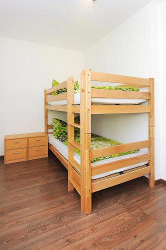 two wooden bunk beds in a room with wooden floors at Haus Hafenromantik in Neuharlingersiel