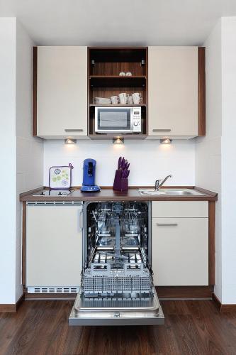 a kitchen with an open dishwasher in a counter at Haus Hafenromantik in Neuharlingersiel