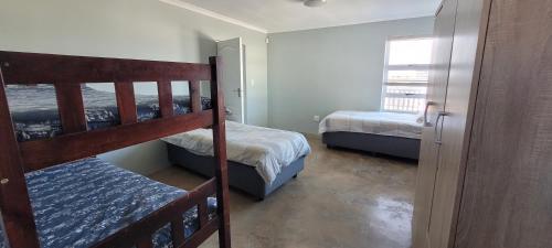 1 dormitorio con 2 literas y escalera en Frances 10 Unit 2, en Struisbaai