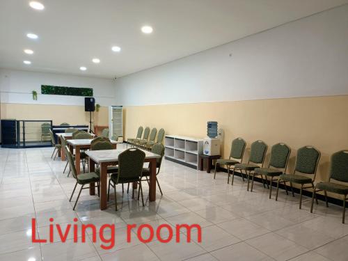 a dining room with tables and chairs and a living room at Chacha Homestay & Dormitory in Ruteng