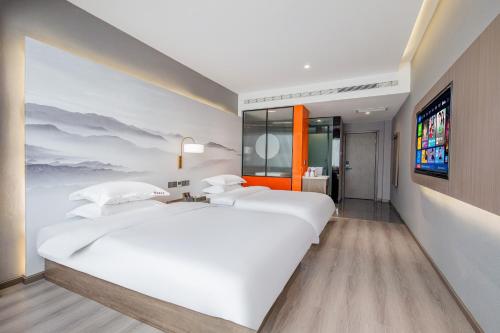 a bedroom with two white beds and a television at 丽江古城丽漫酒店 in Lijiang
