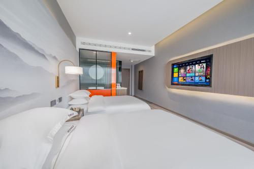 a hotel room with two beds and a flat screen tv at 丽江古城丽漫酒店 in Lijiang
