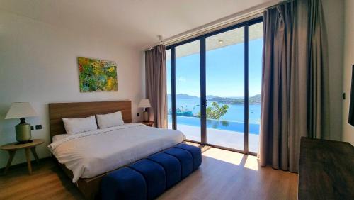 a bedroom with a bed and a large window at Anh Nguyen Oceanfront Luxury Villas Nha Trang in Nha Trang