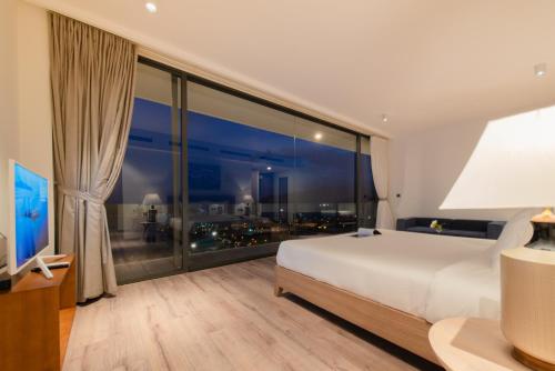 a bedroom with a large bed and a large window at Anh Nguyen Oceanfront Luxury Villas Nha Trang in Nha Trang