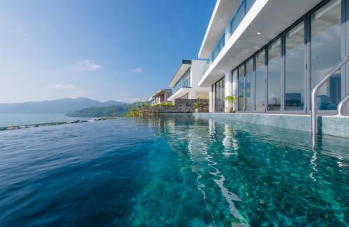a swimming pool in the water next to a building at Anh Nguyen Oceanfront Luxury Villas Nha Trang in Nha Trang