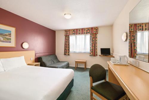 HarthillにあるDays Inn Hotel Sheffield Southのベッドと机があるホテルの部屋