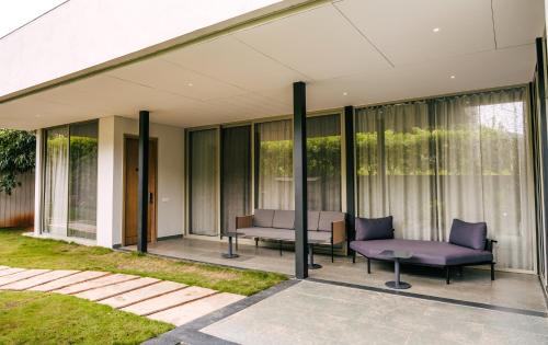a glass house with purple furniture on a patio at ORO The Estates, Nandi Hills in Nandigunda