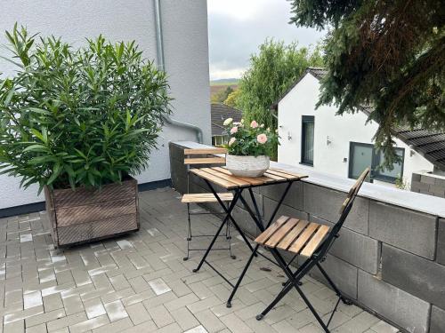 a table and chairs on a balcony with plants at Koblenzer Naturhaus & Apartments in Koblenz