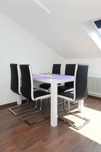 a white table with four chairs around it at Haus Hafenromantik in Neuharlingersiel