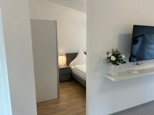 a bedroom with a bed and a tv on a wall at Koblenzer Naturhaus & Apartments in Koblenz