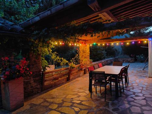 d'une terrasse avec une table, des chaises et des lumières. dans l'établissement Le Mas de la Rode, à Saumane
