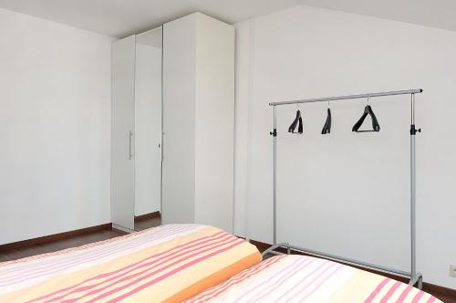 two beds in a room with white walls at Haus Hafenromantik in Neuharlingersiel