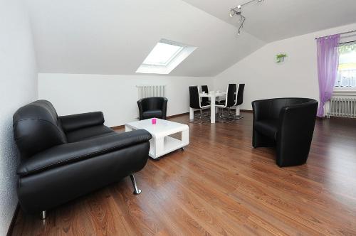 a living room with black chairs and a table at Haus Hafenromantik in Neuharlingersiel