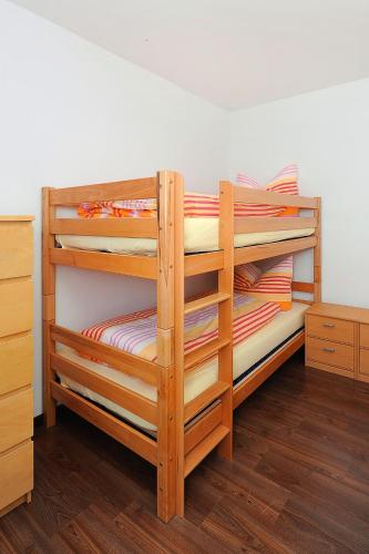 a wooden bunk bed with four bunk beds in a room at Haus Hafenromantik in Neuharlingersiel