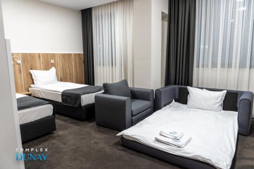 a hotel room with two beds and a couch and a chair at Комплекс Дунав in Ruse