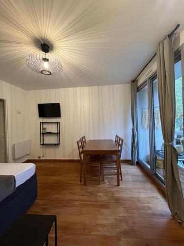 une pièce avec une table, des chaises et une télévision dans l'établissement Porte de Paris Studio standing, à Vanves