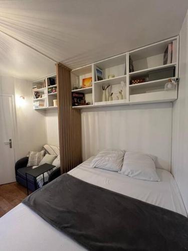 une petite chambre avec un lit et une chaise dans l'établissement Porte de Paris Studio standing, à Vanves