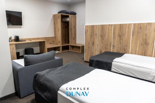a hotel room with two beds and a desk at Комплекс Дунав in Ruse