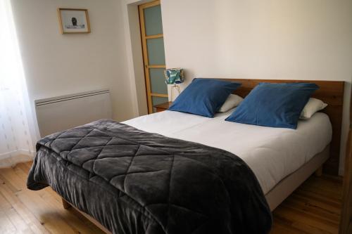 une chambre avec un grand lit avec des oreillers bleus dans l'établissement Grand T3, plein centre, à Bagnères-de-Bigorre