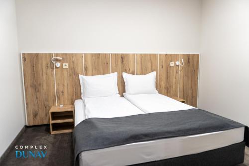 a bedroom with a large bed with a wooden headboard at Комплекс Дунав in Ruse