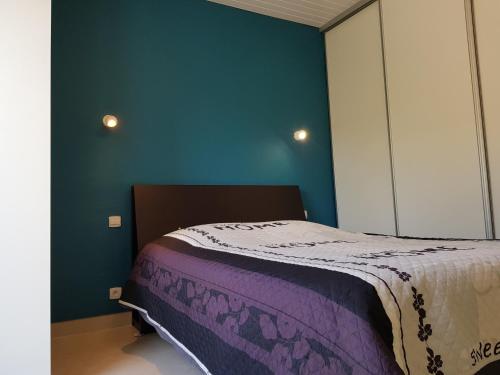 une chambre avec un lit et un mur bleu dans l'établissement Belle villa individuelle de plain pied 6 pers d'environ 90m2 - 6VPRIV19, à Saint Cyprien Plage