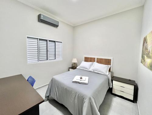 a bedroom with a bed and a desk and a window at Casa do Lago da Dinda 2 in Espirito Santo Do Pinhal