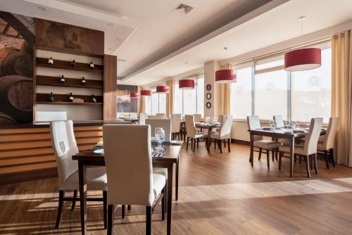 a dining room with tables and chairs and windows at Exe São Lázaro in Bragança