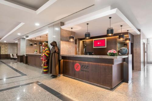 a lobby of a hotel with two women standing at a counter at Exe São Lázaro in Bragança
