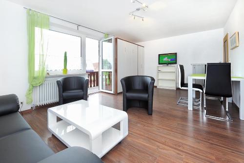 a living room with a white table and black chairs at Haus Hafenromantik in Neuharlingersiel