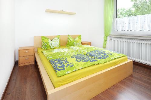 a bedroom with a bed with a yellow comforter and a window at Haus Hafenromantik in Neuharlingersiel