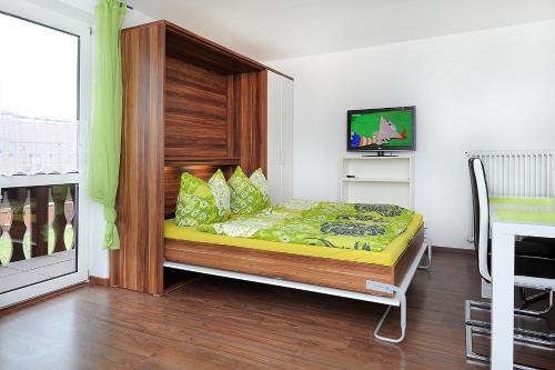 a small bedroom with a bed with a wooden headboard at Haus Hafenromantik in Neuharlingersiel