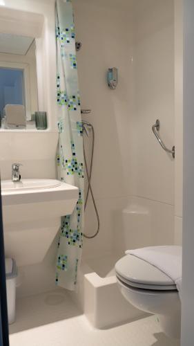 a bathroom with a toilet and a sink and a shower at Vitrin Panzió in Nagymaros