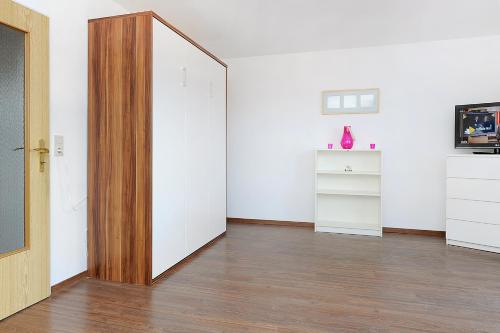 an empty room with a wooden door and white walls at Haus Hafenromantik in Neuharlingersiel