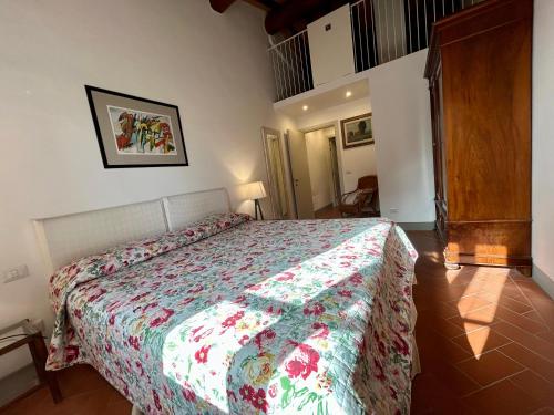 a bedroom with a bed with a floral bedspread at I Casaloni in Panzano