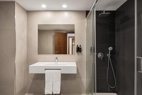 a bathroom with a sink and a shower at Exe São Lázaro in Bragança