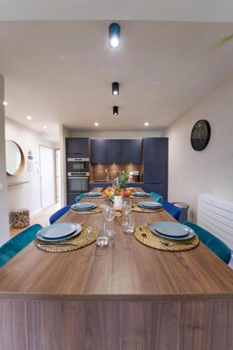 une grande table en bois avec des assiettes et des verres dans l'établissement Duo Aérien-Filets-wifi-clim, à Toulon