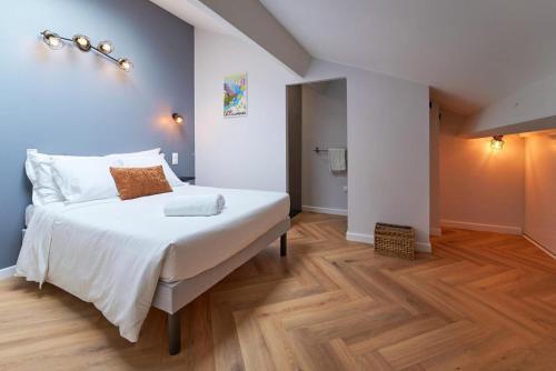 Cette chambre comprend un lit avec des draps blancs et du parquet. dans l'établissement Duo Aérien-Filets-wifi-clim, à Toulon